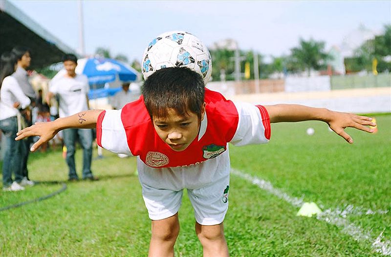 Công Phượng khi còn nhỏ, cùng với trái bóng tự chế từ lá chuối khô, thể hiện tình yêu bóng đá từ thuở ấu thơ.